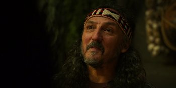 Movie still from “Sayen” (2023), directed by Alexander Witt – A person with long hair wearing a headband; Close Up shot, Over the shoulder angle