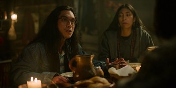 Movie still from “Sayen” (2023), directed by Alexander Witt – Two people sitting at a table with a plate of food in front of them; Medium shot, Over the shoulder angle