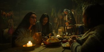 Movie still from “Sayen” (2023), directed by Alexander Witt – Two people sitting at a table with food and candles; Medium shot, Over the shoulder angle