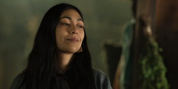 Movie still from “Sayen” (2023), directed by Alexander Witt – A woman with long black hair is smiling; Close Up shot, Over the shoulder angle