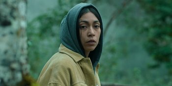 Movie still from “Sayen” (2023), directed by Alexander Witt – A person wearing a hooded jacket in a forest; Close Up shot, Low angle