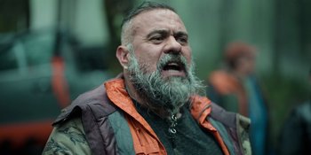 Movie still from “Sayen” (2023), directed by Alexander Witt – A man with a beard and a gray jacket; Close Up shot, Over the shoulder angle