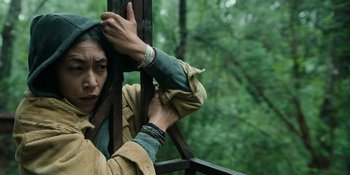 Movie still from “Sayen” (2023), directed by Alexander Witt – A woman is holding her head while standing on a balcony; Close Up shot, High angle