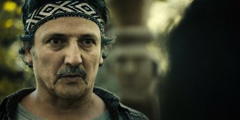 Movie still from “Sayen” (2023), directed by Alexander Witt – A person wearing a head band; Close Up shot, Over the shoulder angle