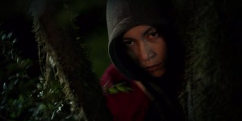 Movie still from “Sayen” (2023), directed by Alexander Witt – A person wearing a hooded jacket in the woods; Close Up shot, Low angle