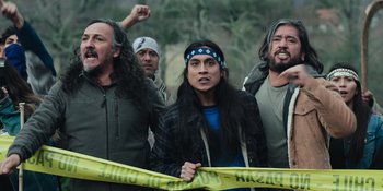 Movie still from “Sayen” (2023), directed by Alexander Witt – A group of men standing next to each other holding a yellow tape; Medium shot, Over the shoulder angle