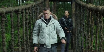 Movie still from “Sayen” (2023), directed by Alexander Witt – A man and a woman walking in the woods; Medium shot, Low angle