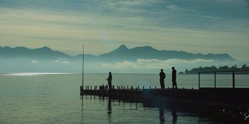Movie still from “Sayen” (2023), directed by Alexander Witt – A group of people fishing on a pier; Extreme Wide shot, Low angle