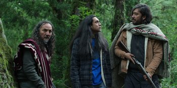 Movie still from “Sayen” (2023), directed by Alexander Witt – A group of people standing next to each other in the woods; Medium shot, Over the shoulder angle