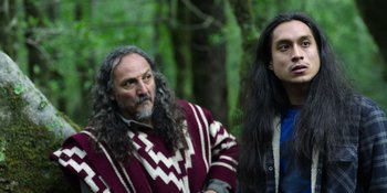 Movie still from “Sayen” (2023), directed by Alexander Witt – A man and a woman standing next to each other in the woods; Medium shot, Over the shoulder angle