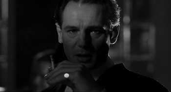 Movie still from “Schindler's List” (1993), directed by Steven Spielberg – Black and white photograph of a man smoking a cigarette; Close Up shot, Low angle