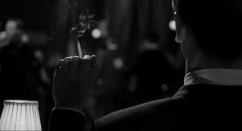 Movie still from “Schindler's List” (1993), directed by Steven Spielberg – A person holding a cigarette in their hand; Extreme Close Up shot, Over the shoulder angle