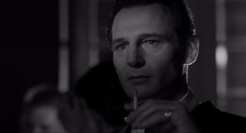 Movie still from “Schindler's List” (1993), directed by Steven Spielberg – Black and white photograph of a man smoking a cigarette; Close Up shot, Over the shoulder angle