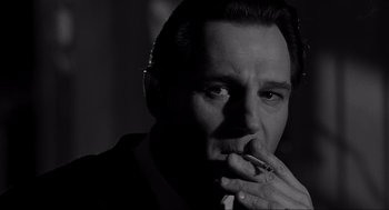 Movie still from “Schindler's List” (1993), directed by Steven Spielberg – Black and white photograph of a man smoking a cigarette; Close Up shot, Low angle