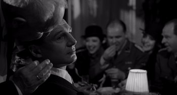 Movie still from “Schindler's List” (1993), directed by Steven Spielberg – A man in a top hat is looking at the camera while two other men watch; Close Up shot, Over the shoulder angle