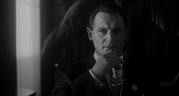 Movie still from “Schindler's List” (1993), directed by Steven Spielberg – Black and white photograph of a man wearing a suit and tie; Close Up shot, Low angle