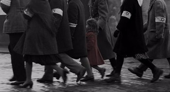 Movie still from “Schindler's List” (1993), directed by Steven Spielberg – A group of people walking down a street with one child; Wide shot, High angle