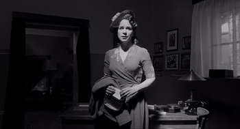 Movie still from “Schindler's List” (1993), directed by Steven Spielberg – A woman in a hat and a dress holding a purse; Medium shot, Low angle