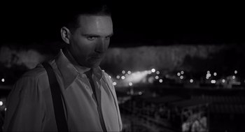 Movie still from “Schindler's List” (1993), directed by Steven Spielberg – A black and white photo of a man in a white shirt and tie; Close Up shot, Low angle