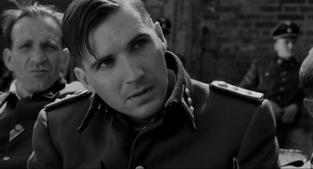 Movie still from “Schindler's List” (1993), directed by Steven Spielberg – Black and white photograph of a man wearing a military uniform; Close Up shot, Over the shoulder angle