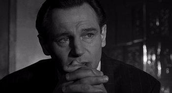 Movie still from “Schindler's List” (1993), directed by Steven Spielberg – Black and white photograph of a man in a suit; Close Up shot, Over the shoulder angle