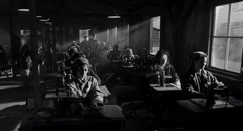 Movie still from “Schindler's List” (1993), directed by Steven Spielberg – A group of people sitting at tables in a room; Wide shot, High angle