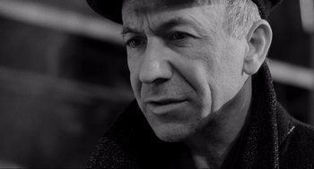 Movie still from “Schindler's List” (1993), directed by Steven Spielberg – Black and white photograph of an older man wearing a hat; Close Up shot, Low angle