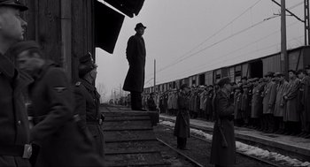 Movie still from “Schindler's List” (1993), directed by Steven Spielberg – An old photo of a man standing on a train platform; Wide shot, Low angle