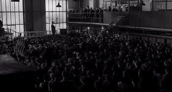 Movie still from “Schindler's List” (1993), directed by Steven Spielberg – A large group of people are gathered in a large room; Extreme Wide shot, High angle