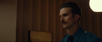 Movie still from “BlacKkKlansman” (2018), directed by Spike Lee – A person with a mustache; Close Up shot, Over the shoulder angle