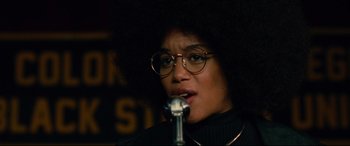 Movie still from “BlacKkKlansman” (2018), directed by Spike Lee – A person with a microphone in a dark room; Close Up shot, Low angle