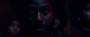 Movie still from “BlacKkKlansman” (2018), directed by Spike Lee – A person's face in the dark; Extreme Close Up shot, Low angle