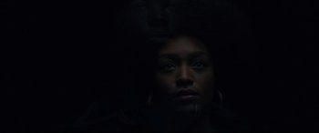 Movie still from “BlacKkKlansman” (2018), directed by Spike Lee – A woman is looking at the camera in the dark; Close Up shot, Low angle