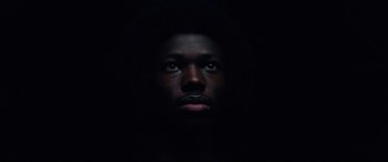 Movie still from “BlacKkKlansman” (2018), directed by Spike Lee – A man with a beard is in the dark; Close Up shot, Overhead angle