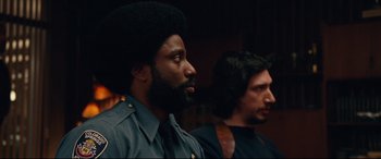 Movie still from “BlacKkKlansman” (2018), directed by Spike Lee – A man with an afro and a man with a beard; Close Up shot, Over the shoulder angle
