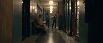 Movie still from “BlacKkKlansman” (2018), directed by Spike Lee – A man sitting on top of a bench reading a newspaper; Wide shot, Over the shoulder angle