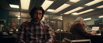 Movie still from “BlacKkKlansman” (2018), directed by Spike Lee – A man with long hair and a plaid shirt in an office; Medium shot, Over the shoulder angle