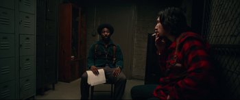 Movie still from “BlacKkKlansman” (2018), directed by Spike Lee – A man sitting on a chair in front of a woman; Medium shot, Over the shoulder angle