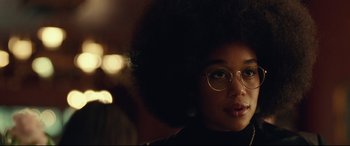 Movie still from “BlacKkKlansman” (2018), directed by Spike Lee – A young woman with glasses is looking at the camera; Close Up shot, Over the shoulder angle
