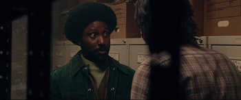 Movie still from “BlacKkKlansman” (2018), directed by Spike Lee – A man in a green jacket talking to another man in a brown jacket; Close Up shot, Over the shoulder angle