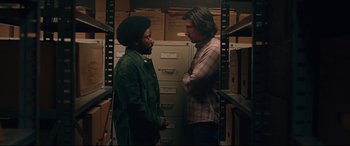 Movie still from “BlacKkKlansman” (2018), directed by Spike Lee – Two men standing next to each other in a storage room; Medium shot, Over the shoulder angle