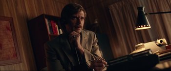 Movie still from “BlacKkKlansman” (2018), directed by Spike Lee – A man in a brown suit is talking on a phone; Medium shot, Low angle