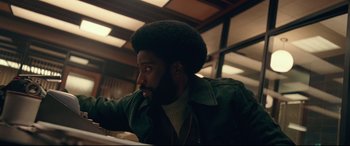 Movie still from “BlacKkKlansman” (2018), directed by Spike Lee – A person wearing a jacket; Medium shot, Low angle