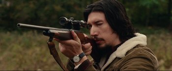 Movie still from “BlacKkKlansman” (2018), directed by Spike Lee – A man holding a rifle while wearing a watch; Close Up shot, Over the shoulder angle