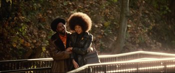 Movie still from “BlacKkKlansman” (2018), directed by Spike Lee – A man standing next to a woman in a leather jacket; Medium shot, Low angle