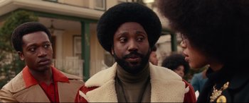Movie still from “BlacKkKlansman” (2018), directed by Spike Lee – A person with a beard wearing a jacket; Close Up shot, Over the shoulder angle