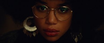 Movie still from “BlacKkKlansman” (2018), directed by Spike Lee – A person wearing glasses and looking at the camera; Extreme Close Up shot, Low angle