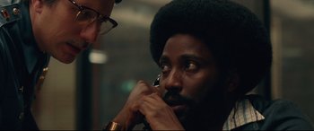 Movie still from “BlacKkKlansman” (2018), directed by Spike Lee – A man with a beard is talking on a phone; Close Up shot, Over the shoulder angle