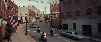 Movie still from “BlacKkKlansman” (2018), directed by Spike Lee – A group of people riding motorcycles down a street; Extreme Wide shot, High angle