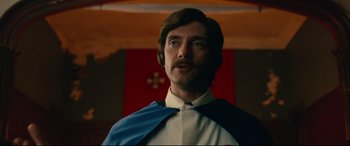 Movie still from “BlacKkKlansman” (2018), directed by Spike Lee – A man in a white shirt and a blue and white cape; Close Up shot, Low angle
